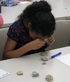 4th grader using lens to examine rocks sample